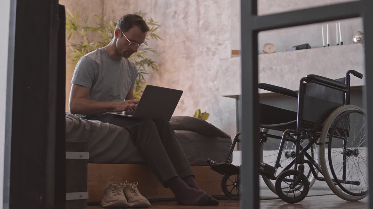 Uomo disabile usa il computer a letto