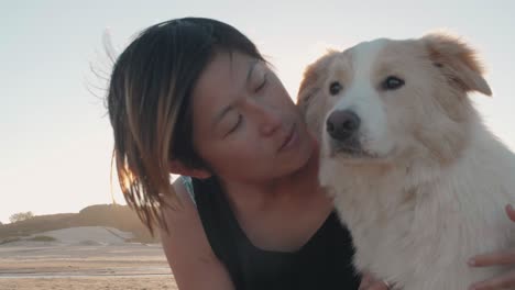 woman with her pet dog on the beach at sunset