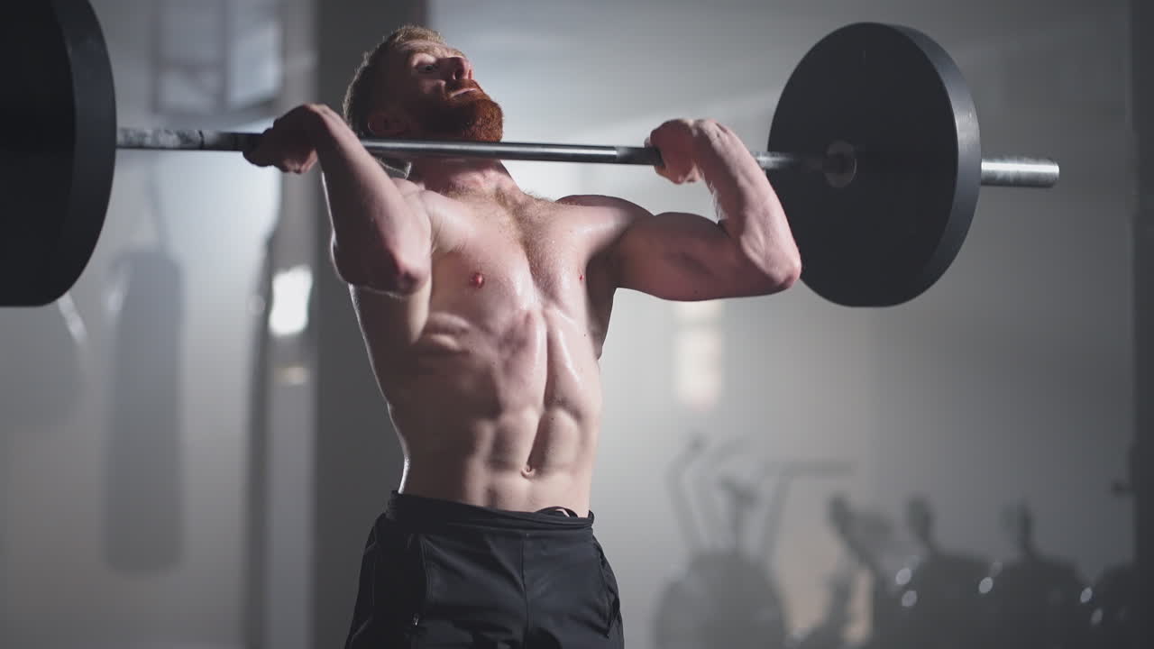 체육적인 아름다운 남자가 체육관에서 바벨로 오버헤드 데드리프트를 합니다. 멋진 남성 프로 보디빌더 운동체육체육체육체육체육체육체육체육체육체육체육체육체육