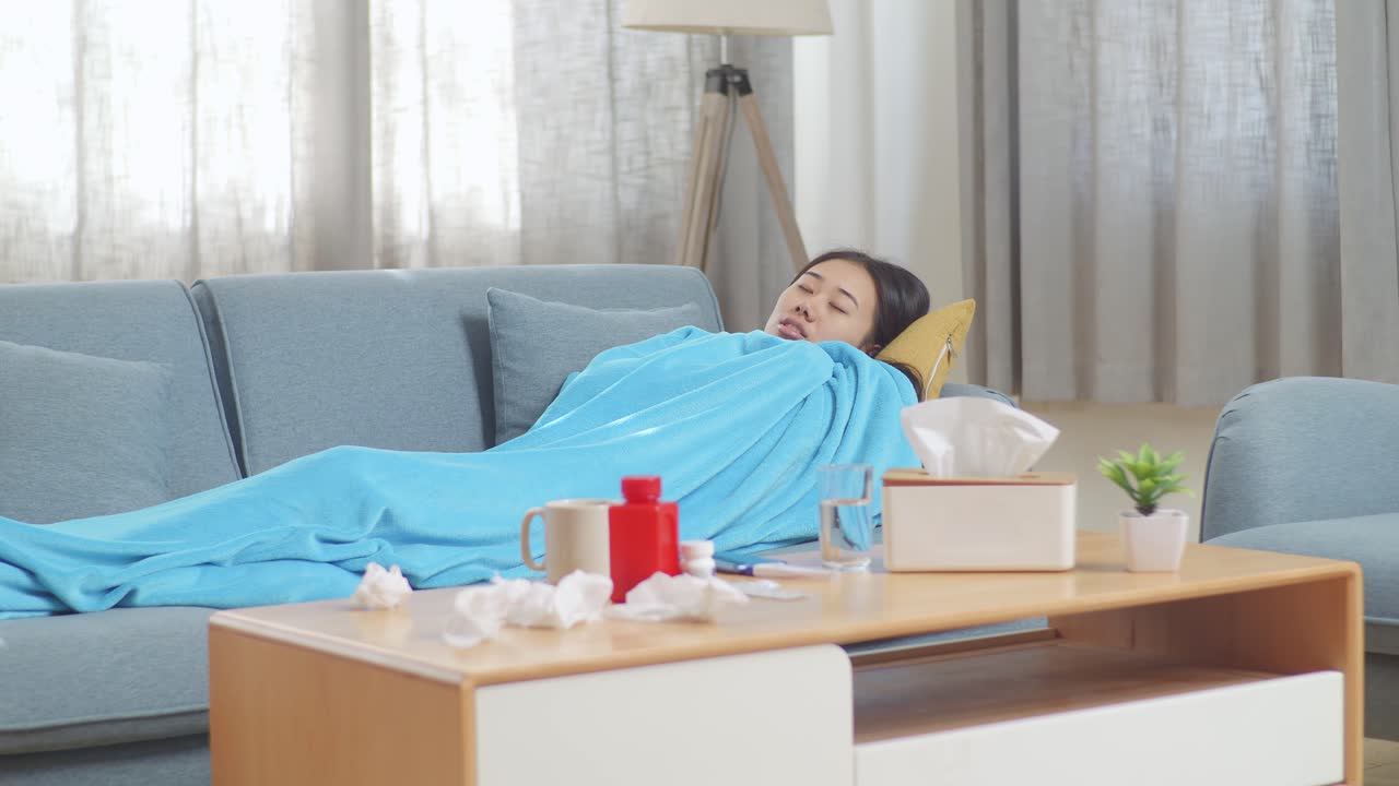 병든 여자 가 소파 에 쉬고 있다