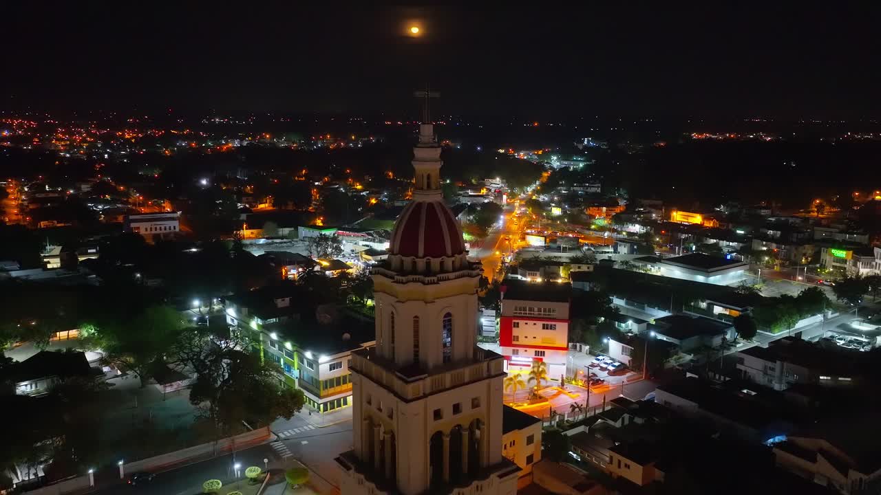 Sacred Heart of Jesus Church or Iglesia Sagrado Corazón De Jesus at night with moon in dark sky, Moca in Dominican Republic