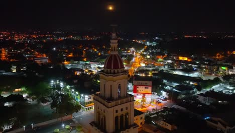 sacred heart of jesus church or iglesia sagrado corazón de jesus at night with moon in dark sky, moca in dominican republic