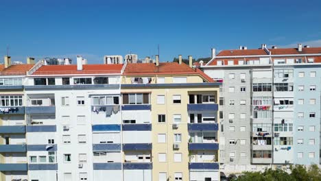 Cityscape-of-Lisbon-Portugal-revealed-by-a-drone-shot-starting-from-a-view-of-a-front-building-and-slowly-ascends-to-show-the-view-of-the-city