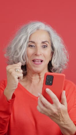senior woman's joyful reaction to smartphone news