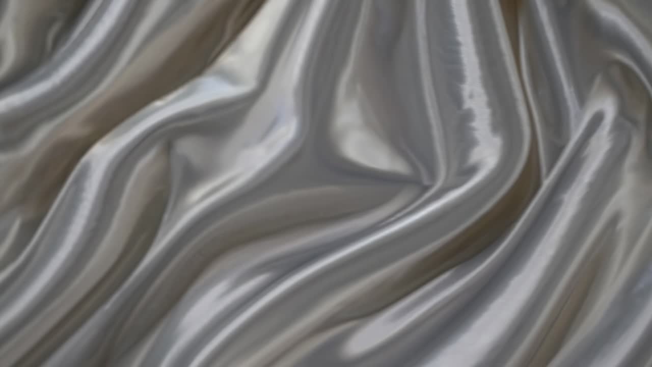 Video ravvicinato di un tessuto di raso bianco liscio e fluido, che ne mette in mostra la texture lucida ed elegante