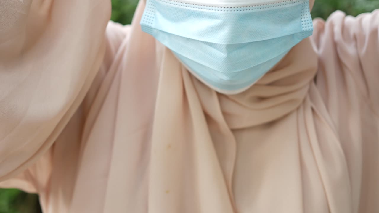 mujeres jóvenes poniendo máscaras al aire libre,