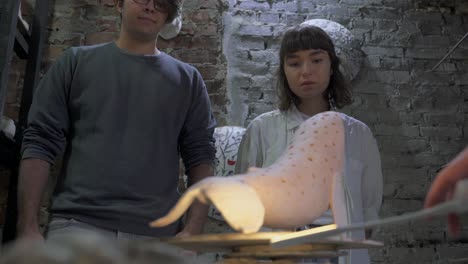 students observing a whale sculpture being fired in a pottery workshop