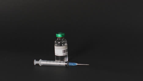 Video-of-close-up-of-vaccine-vial-on-black-background