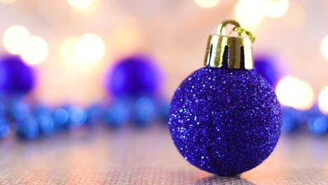 adornos de navidad azules para el árbol de navidad en la mesa con luces parpadeantes