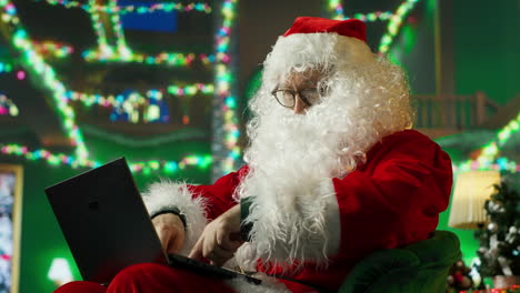 santa claus working on a laptop during christmas