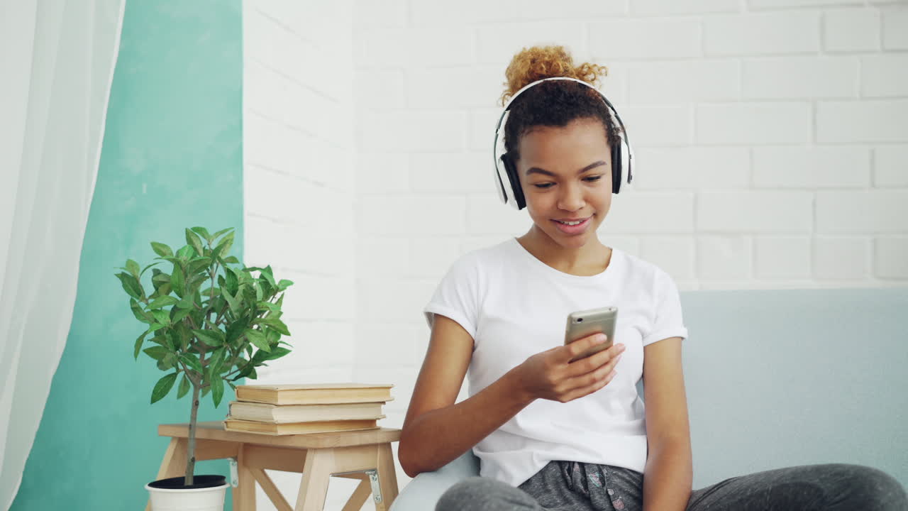 Giovane donna che ascolta musica e usa il telefono