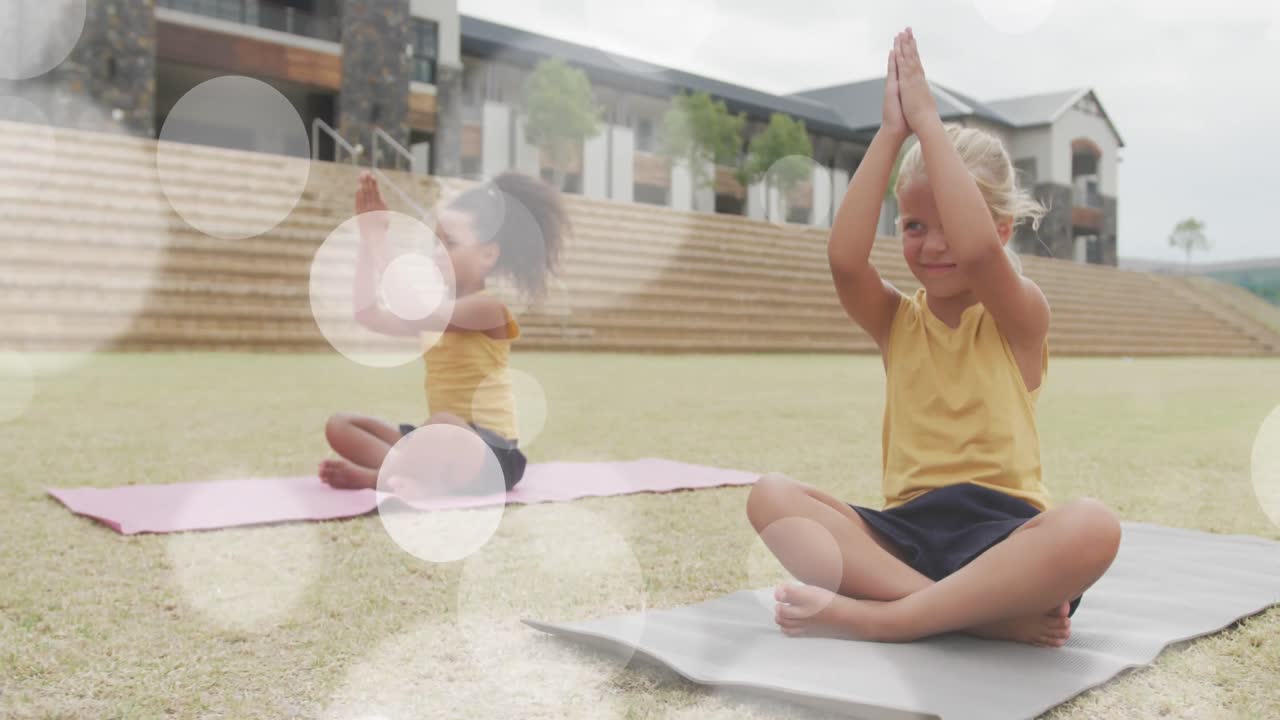 animación de puntos de luz sobre alegres escolares diversas sentadas en clase de yoga al aire libre