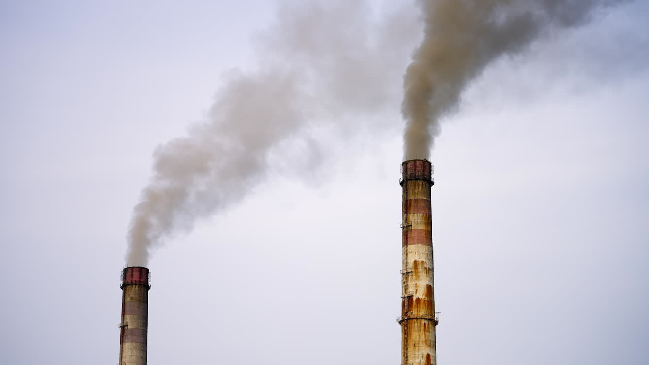 Old pipes with massive smoke in the sky. Dangerous emissions going up in the air. Pollution of the environment. Ecological problems.