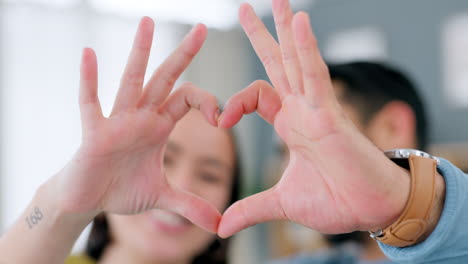 happy couple making heart shape with hands