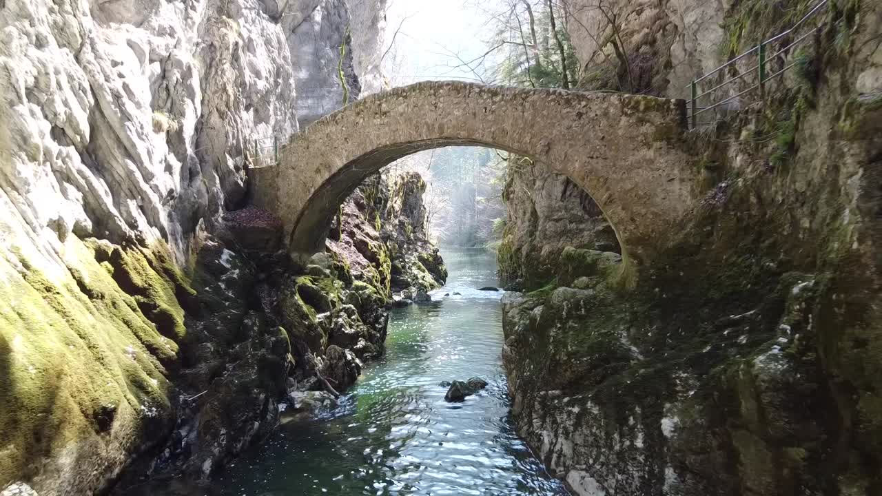 Stone Arch Bridge over a River in a Rocky Canyon