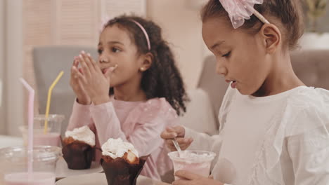 little sisters eating desserts at home