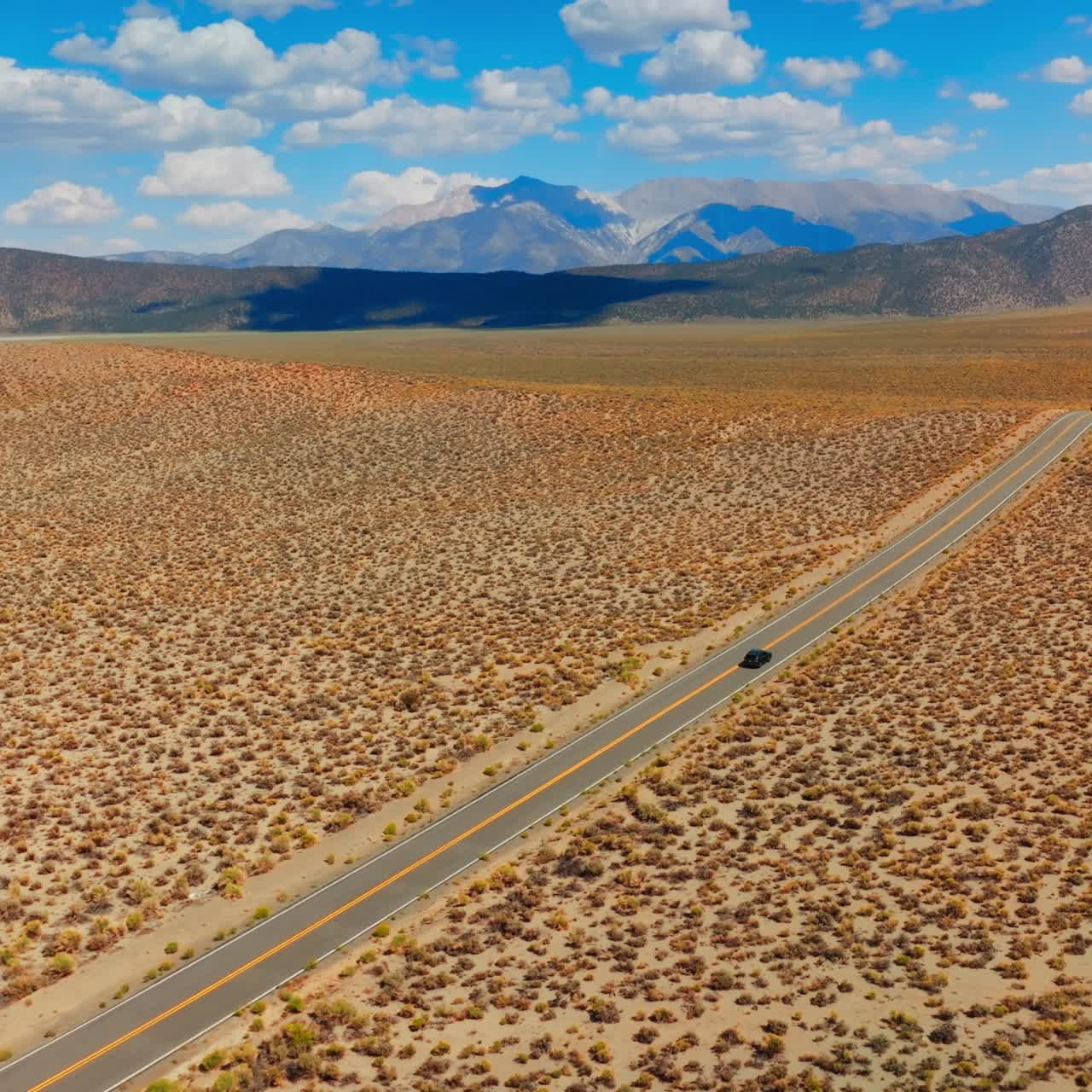 Road trip from California to Nevada through the lifeless desert. Amazing blue skies with white clouds at backdrop