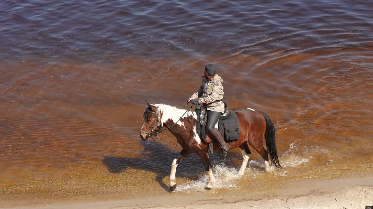 mujer a caballo en un río poco profundo