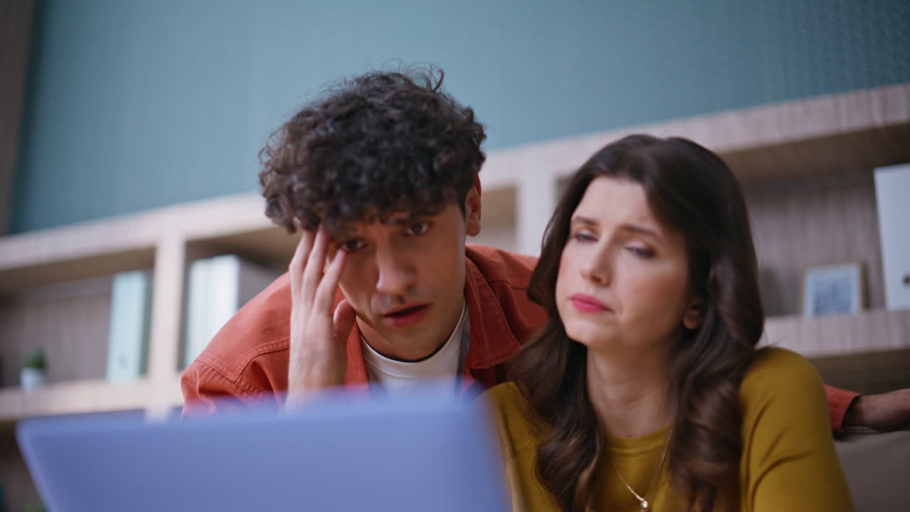 Colleagues disappointed startup failure reading bad news at laptop closeup