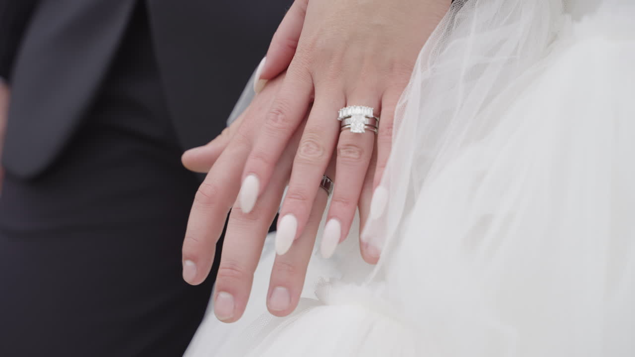 Close Up of Couple Holding Hands with Wedding Rings on their Wedding Day