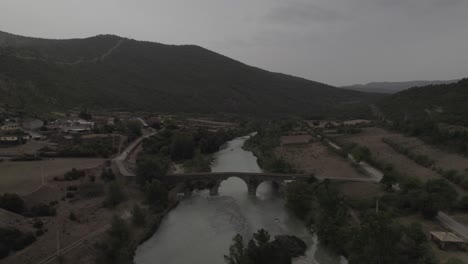 This drone video features a Sam Kolder-style shot, flying under an ancient bridge and pulling away to a bird's-eye view over the Gállego River in Anzánigo, Spain. Stunning visuals!