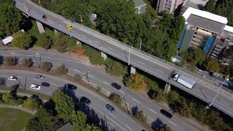 Aerial-dolly-roll-over-Granville-Island-Bridge-park-residential-community-on-a-hot-summer-afternoon-with-minimul-people-and-cars-out-during-COVID-19-pandemic-lockdown-False-Creek-lush-green-park-2-4