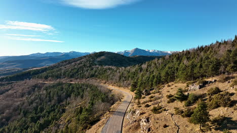 aerial view of a winding road snaking through pyrenees peaks.