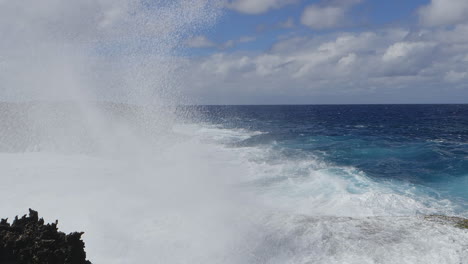 large waves crashing against rocky pacific island cliffs, powerful ocean swell