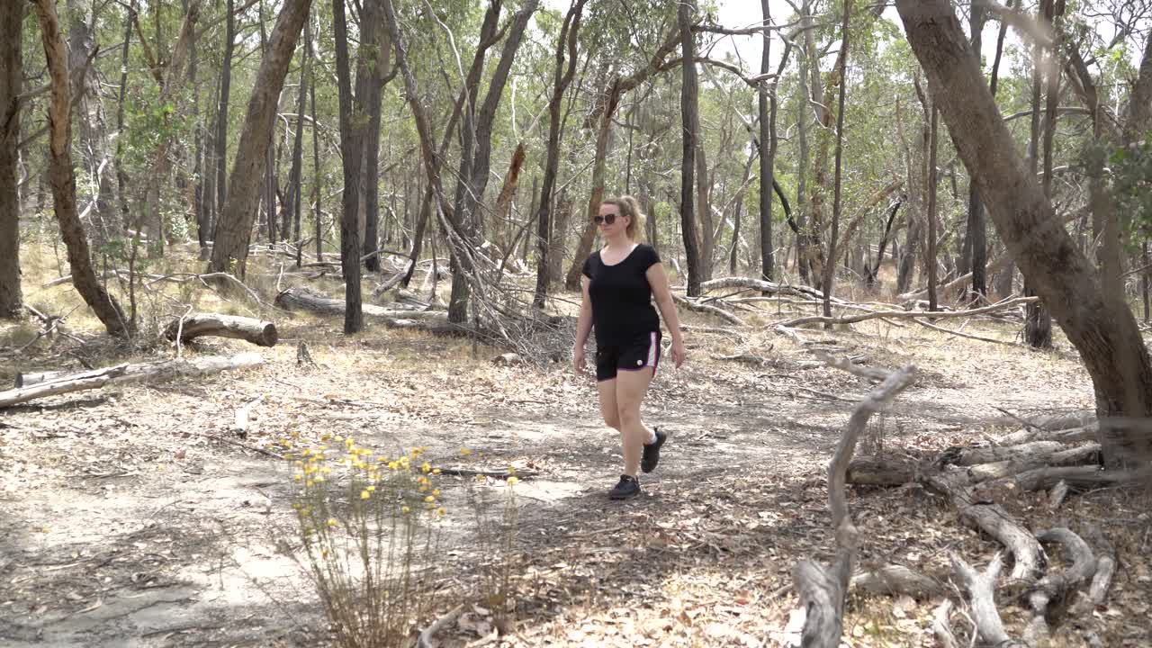 mujer rubia en una caminata por la naturaleza en un parque nacional