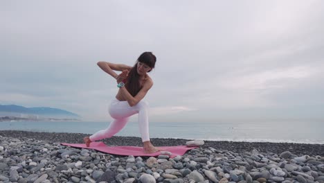 mujer practicando yoga en una playa