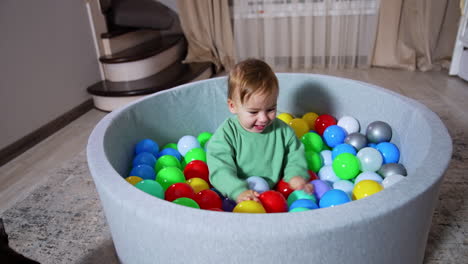 baby playing in a ball pit