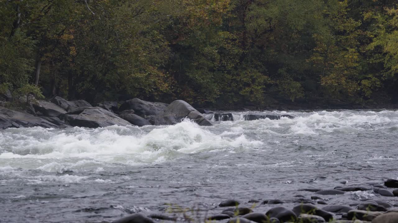 Inquadratura statica di una grande quantità d'acqua che scorre attraverso la gola del fiume.