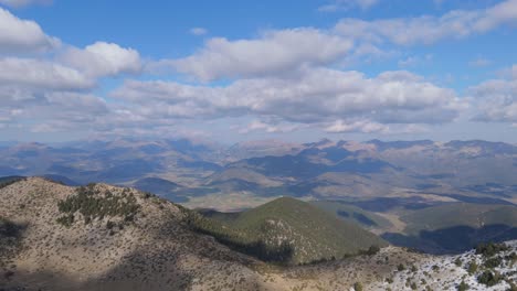 Wunderschöner-Blauer-Himmel-Mit-Flauschigen-Langen-Wolken,-Die-Schatten-Auf-Die-Berge-Des-Peloponnes-Tals-Werfen