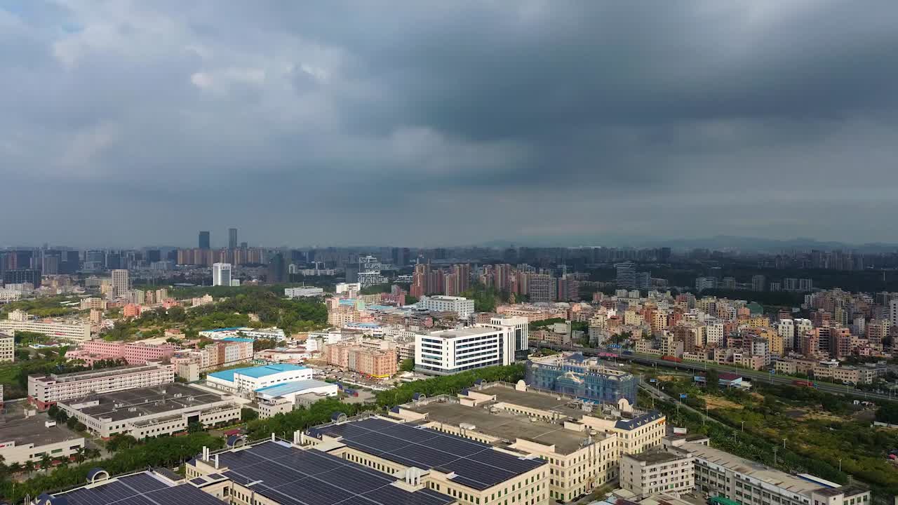Aerial: cityscape with cloudy sky during the day in Dongguan, central Guangdong Province, China, establishing drone shot