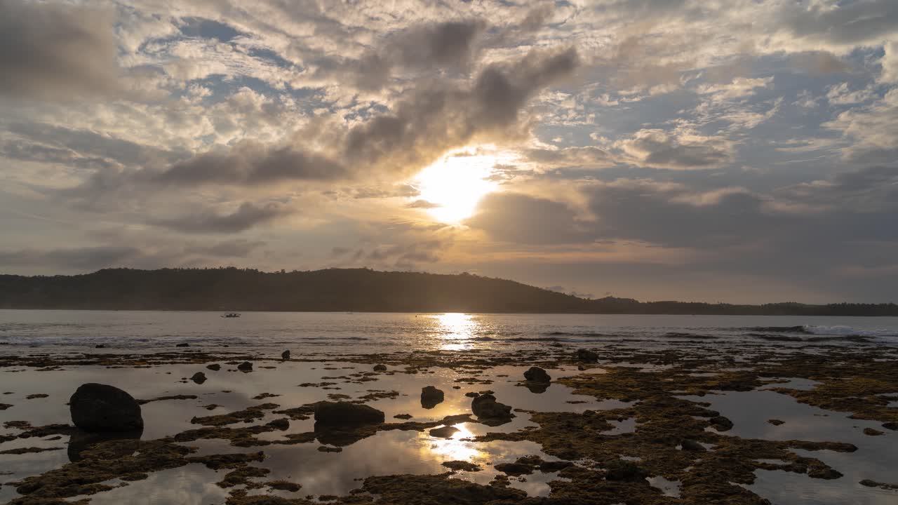 Tropical Coastal Landscape with Rocky Shore and Sun Breaking Through Clouds