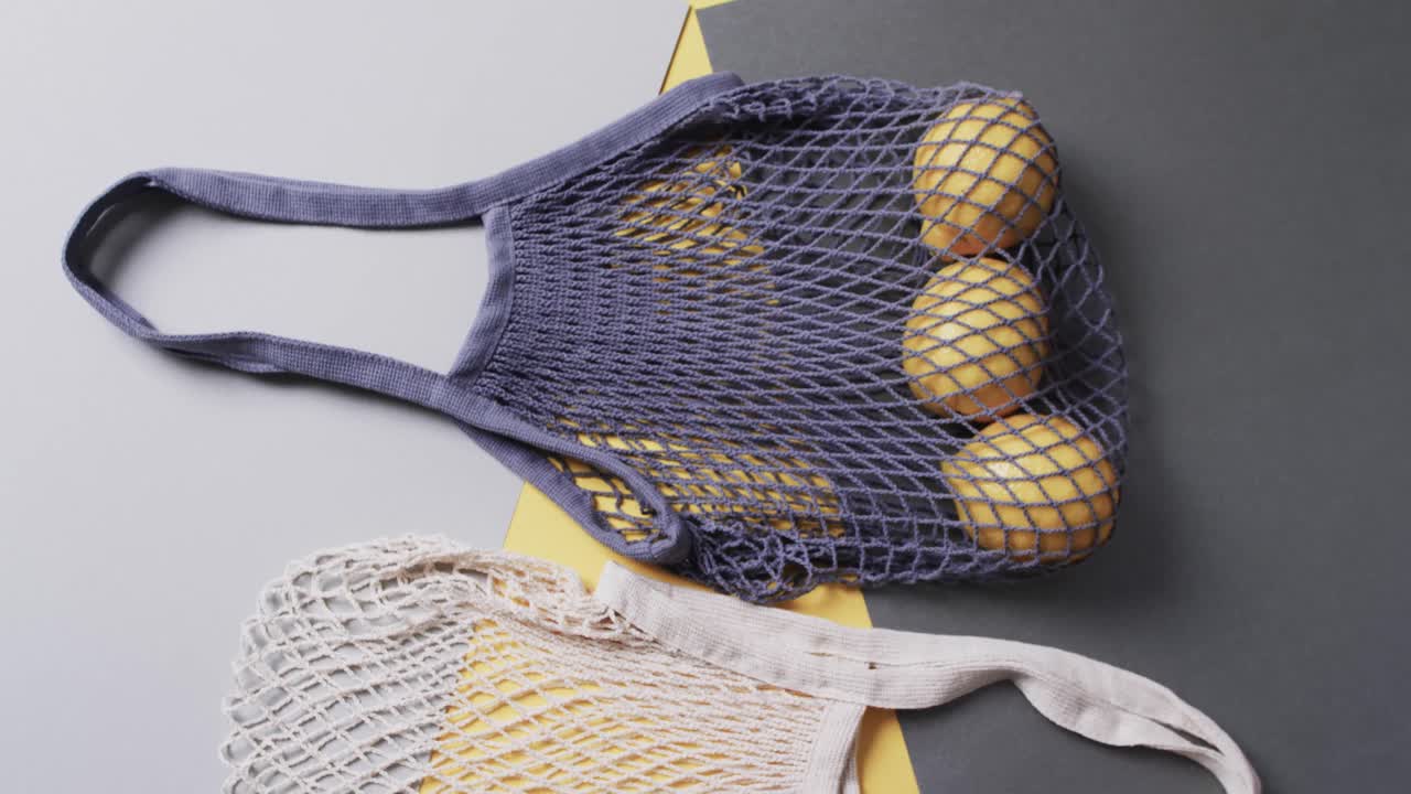 회색과 노란색 배경에 레몬과 복사 공간을 가진 파란색과  ⁇ 색 가방의 비디오