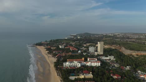 Toma-Aérea-En-órbita-Matutina-De-Complejos-Turísticos-En-Mui-Ne,-Vietnam,-Con-Una-Luz-Dorada,-Con-Piscinas,-Playas,-Edificios-Y-Jardines.