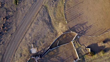 Aérea-Del-Paisaje-Desolado-Y-Corral-Vacío-En-Una-Estancia-Cerca-De-Las-Cuevos-De-Los-Manos