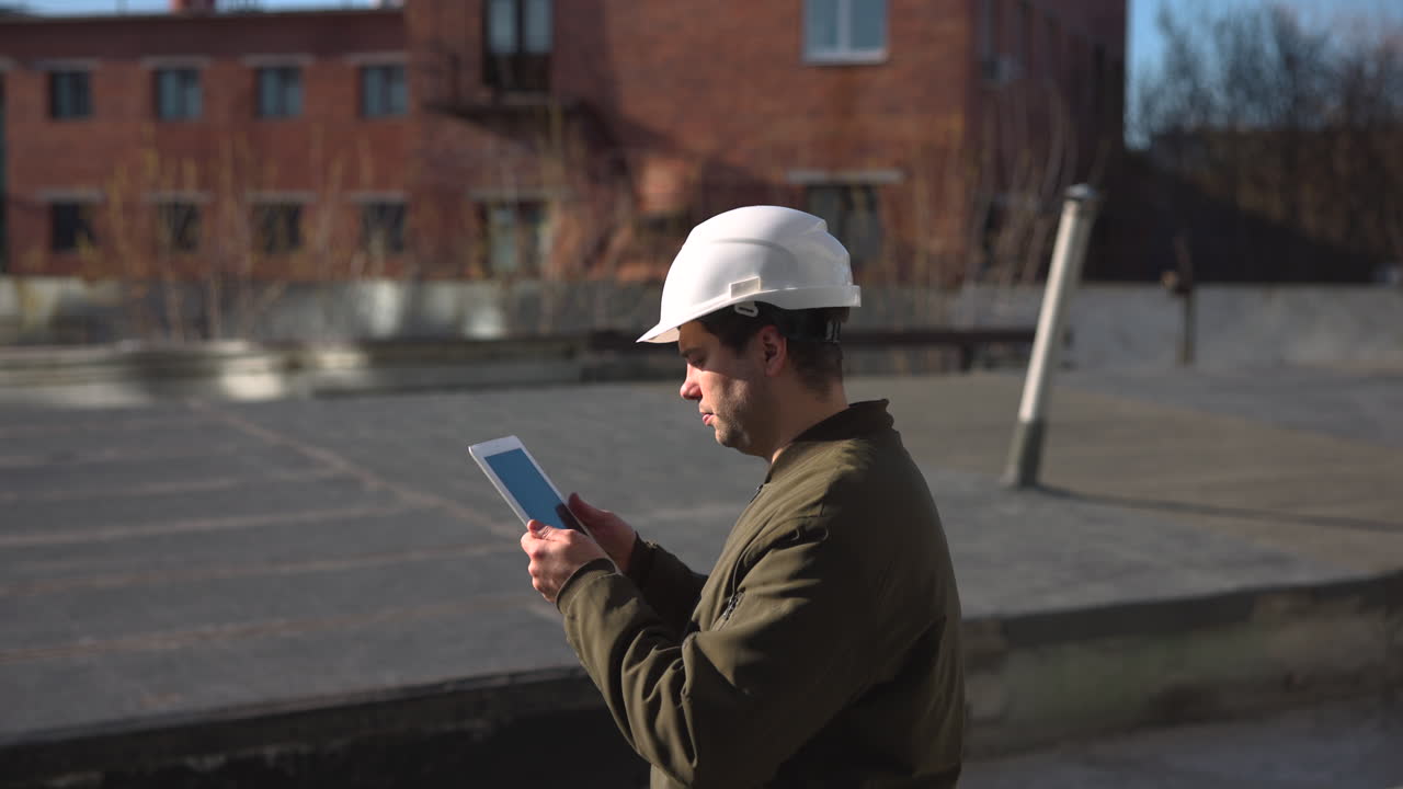 Rooftop Inspector Using Tablet For Survey, Daylight Sunlight On Flat Roof, Urban Building Backdrop, Scanning