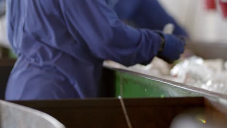 trabajadores que usan ppe seleccionando y clasificando residuos plásticos para su reciclaje