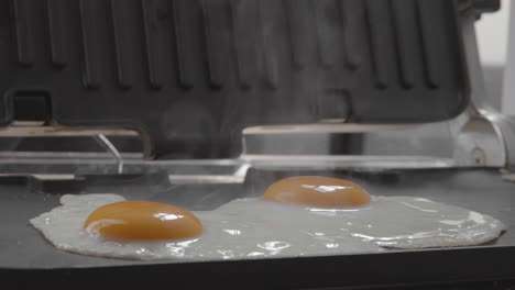 breakfast with fried eggs cooked on electric grill