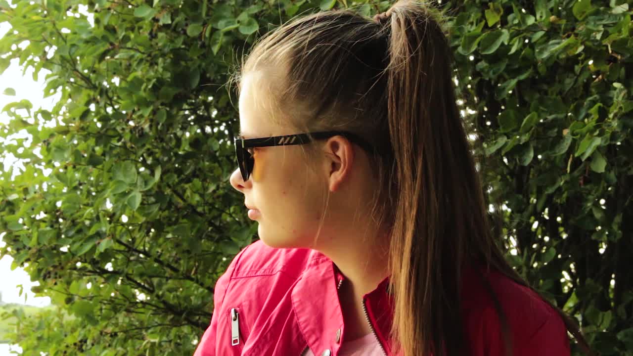 Menina sentada ao ar livre, olhando para fora