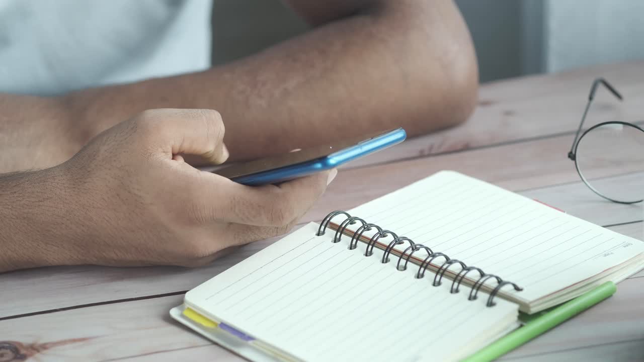 Person using smartphone and notebook