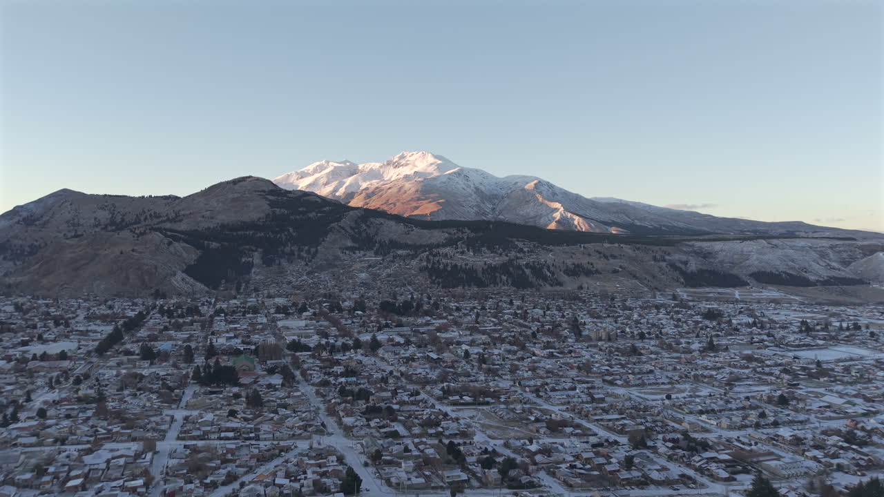 Esquel aerial mountain cityscape surrounded by snow-covered peaks during cold season, Province of Chubut, Argentina