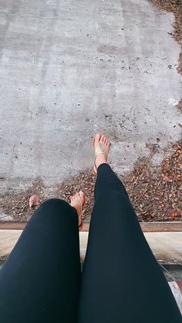 Person sitting on concrete with feet dangling
