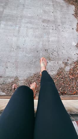 person sitting on concrete with feet dangling