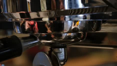 close-up of locking in a portafilter on an espresso machine in a coffee shop