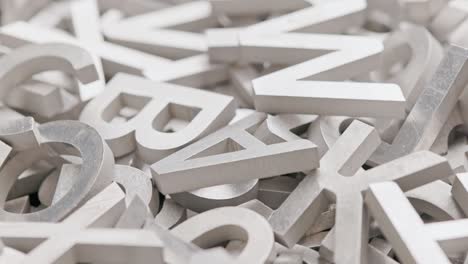 full frame close-up looped slowly rotating background of silver metal letters with selective focus