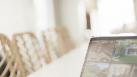 Biracial-man-using-tablet-with-home-security-camera-views-on-screen