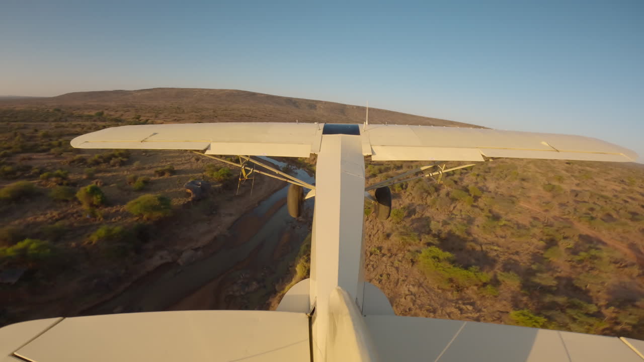 Aereo leggero sopra un fiume nella savana del Kenya durante la sera